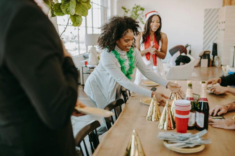Cheerful group celebrating a holiday office party with decorations and festive attire.