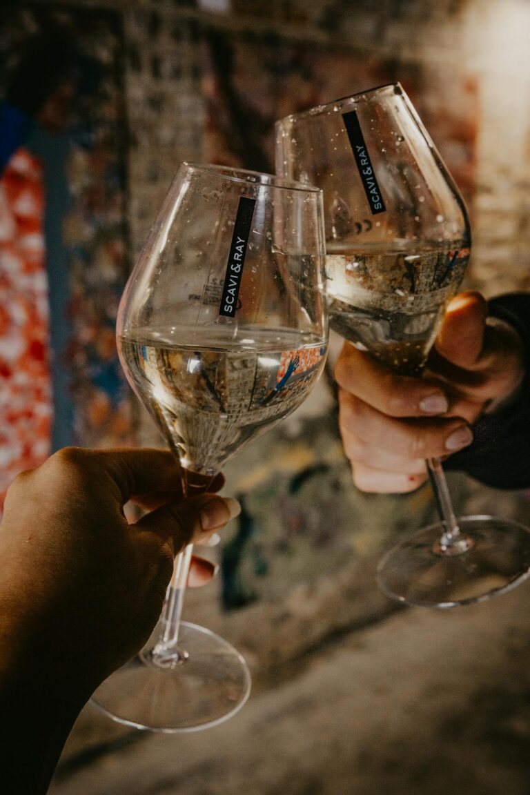 Two people clinking glasses at an art event, creating a festive atmosphere.